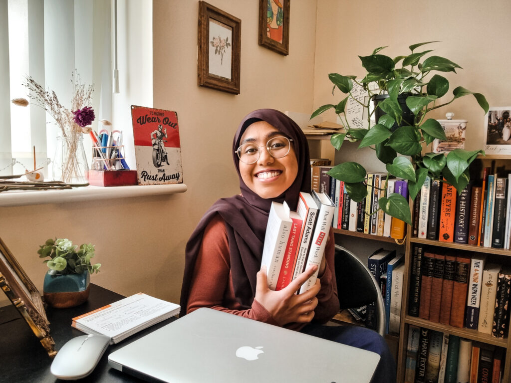Aziza holding a bunch of books